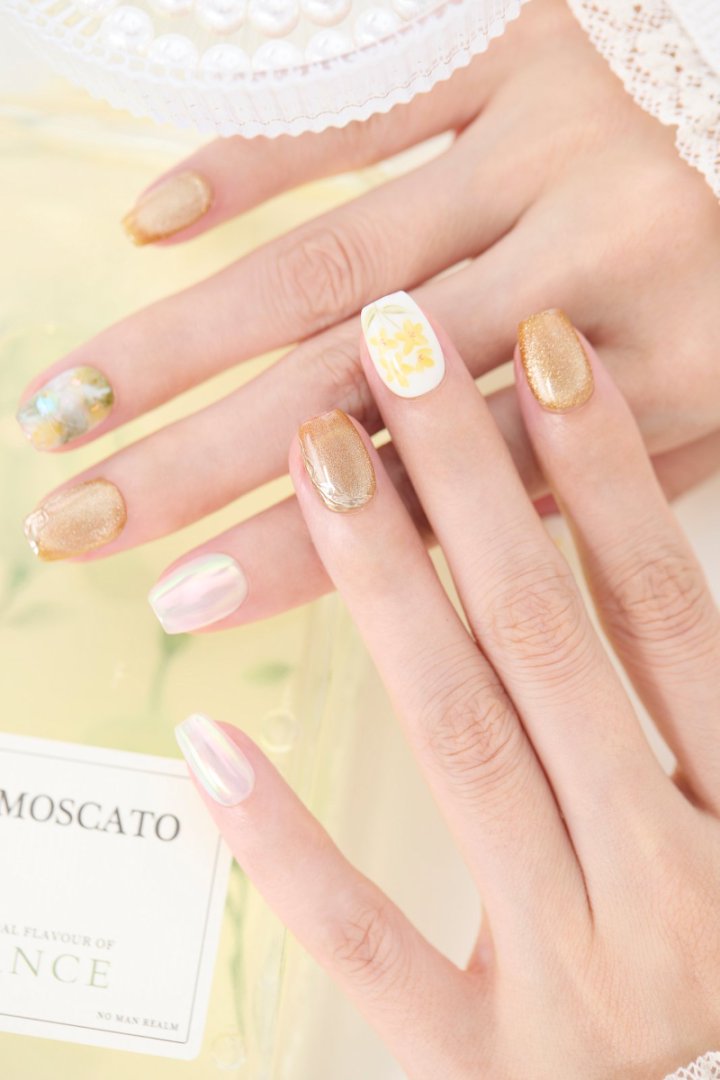 ootd.nail イエローフラワー ジェルネイルチップ 着用イメージ|黄色い花柄とゴールド、オーロラの輝きが美しいデザイン。指先を華やかに魅せる、繰り返し使えるジェルネイルチップ。