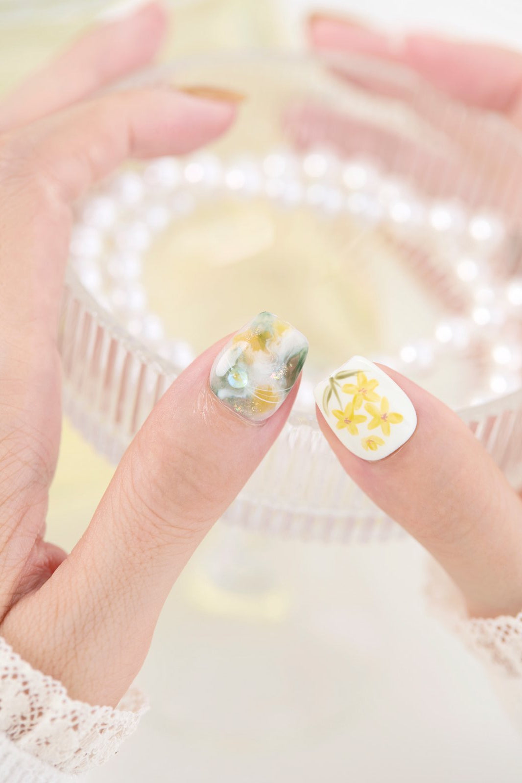 ootd.nail イエローフラワー ジェルネイルチップ 着用イメージ|黄色い花柄とゴールド、オーロラの輝きが美しいデザイン。指先を華やかに魅せる、繰り返し使えるジェルネイルチップ。