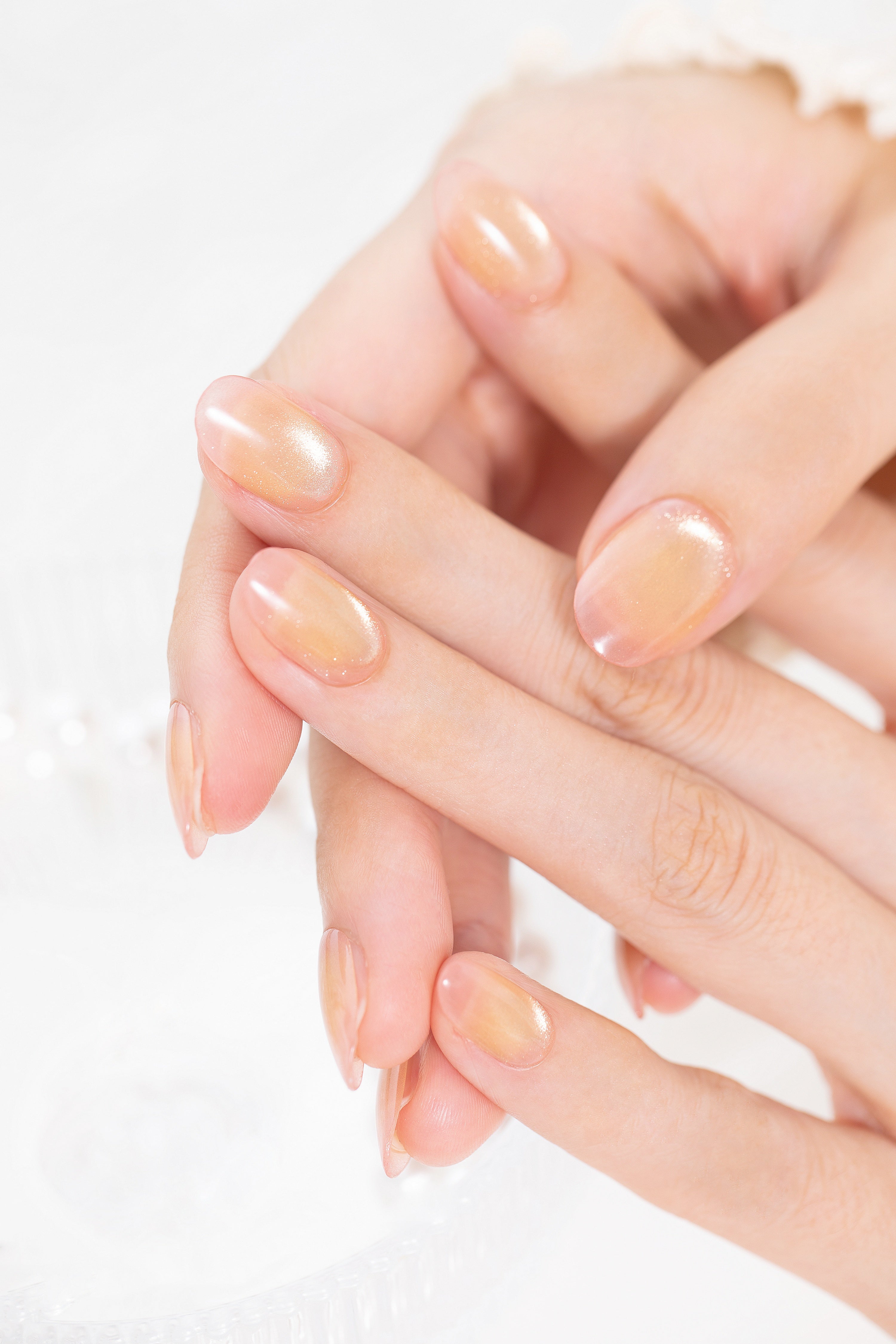 シアーアプリコット × ゴールドパール ジェルネイルチップ 着用イメージ｜透け感アプリコットに微細ゴールドのツヤがとけ込む、指先美人のナチュラルネイル。オフィス・デート・毎日に使える万能ニュアンス。

