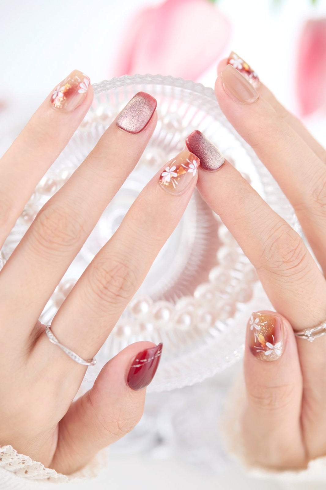 ootd.nail レッドフラワー ジェルネイルチップ 着用イメージ｜深みのあるレッドとベージュに白い花をあしらった華やかなデザイン。上品な指先を演出する、繰り返し使えるジェルネイルチップ。